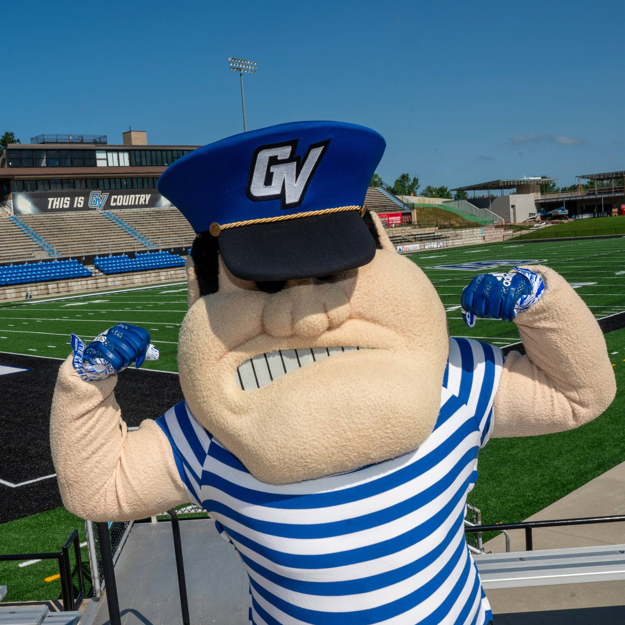 Louie the Laker flexing his muscles on the football field